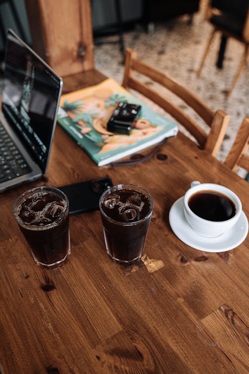 Cold Drinks and a Cup of Coffee on a Desk 