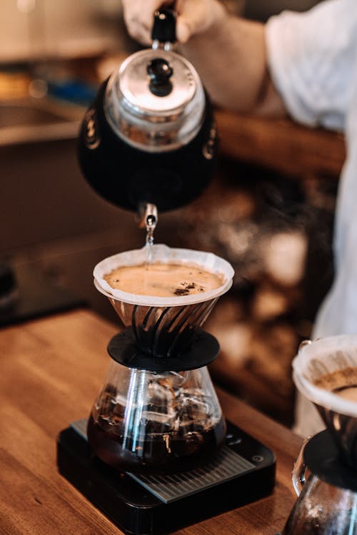 Free Pouring Water from Kettle to Pitcher with Coffee Stock Photo