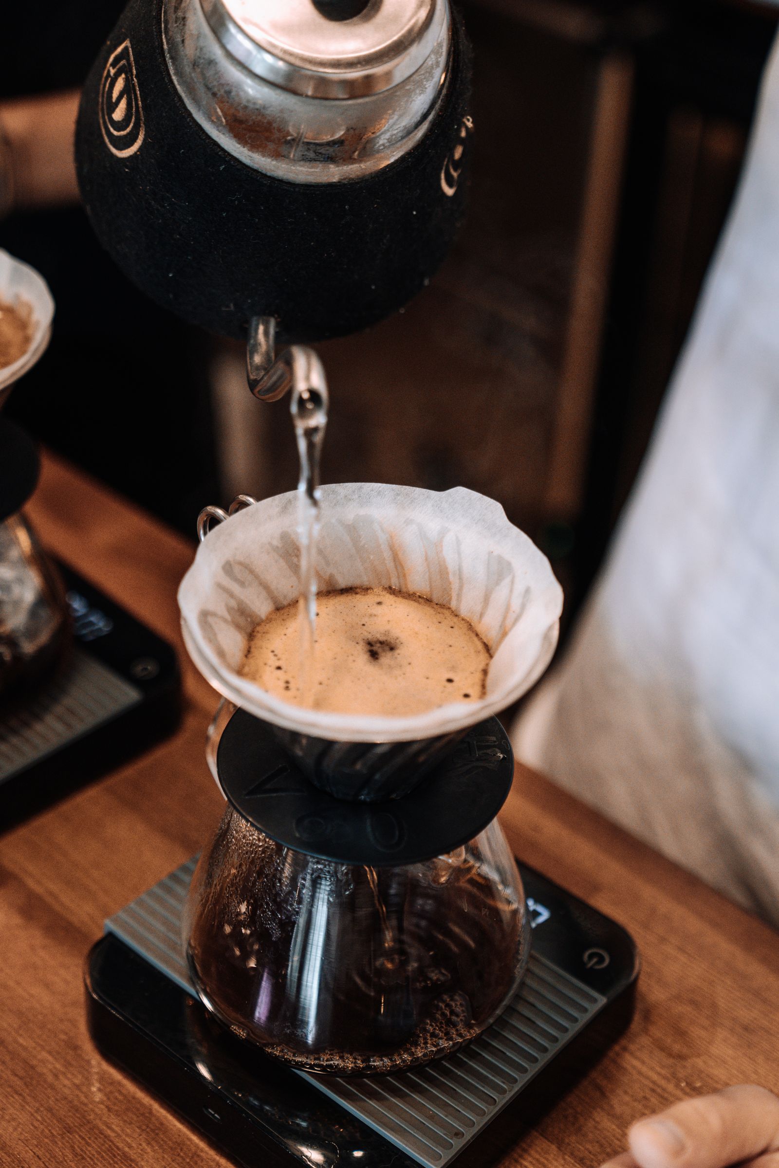 Prim-plan cu apă turnată peste cafea proaspăt măcinată