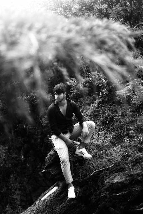 Man Sitting and Posing in Forest in Black and White