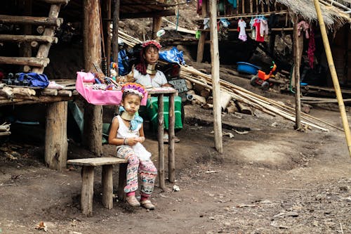 A Kid Sitting on the Wooden Bench