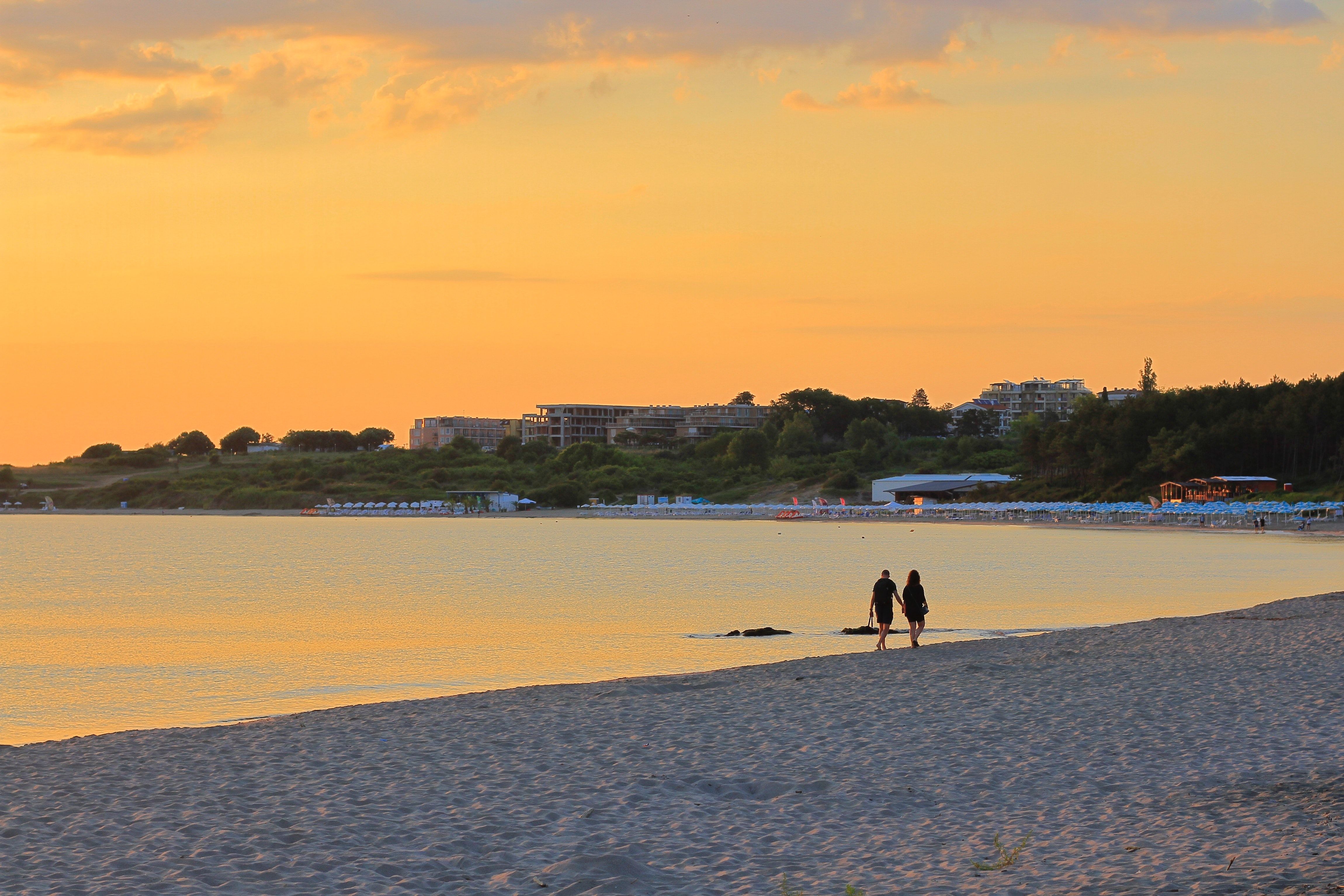 Couple Walking on Beach at Sunset · Free Stock Photo