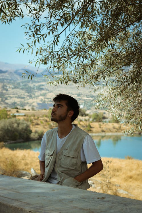 Man Sitting by Table under Tree Leaves