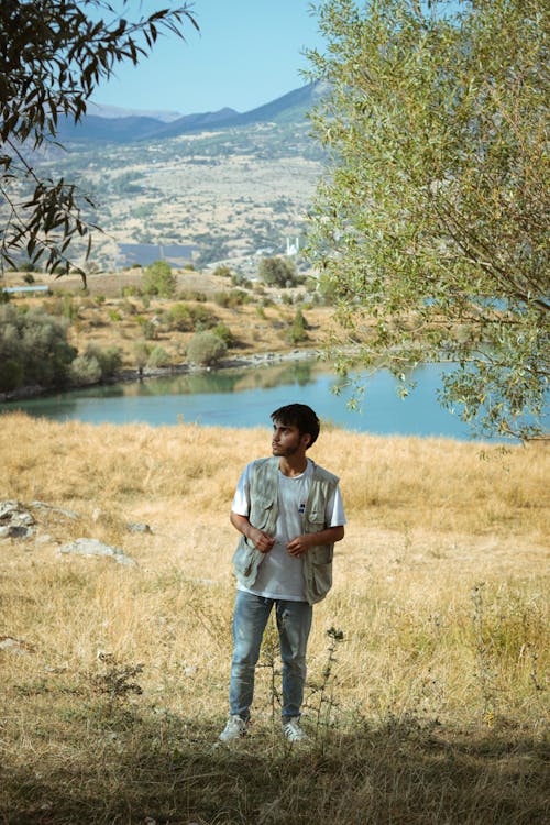 Young Man Posing in Multi-Pocket Vest and Jeans