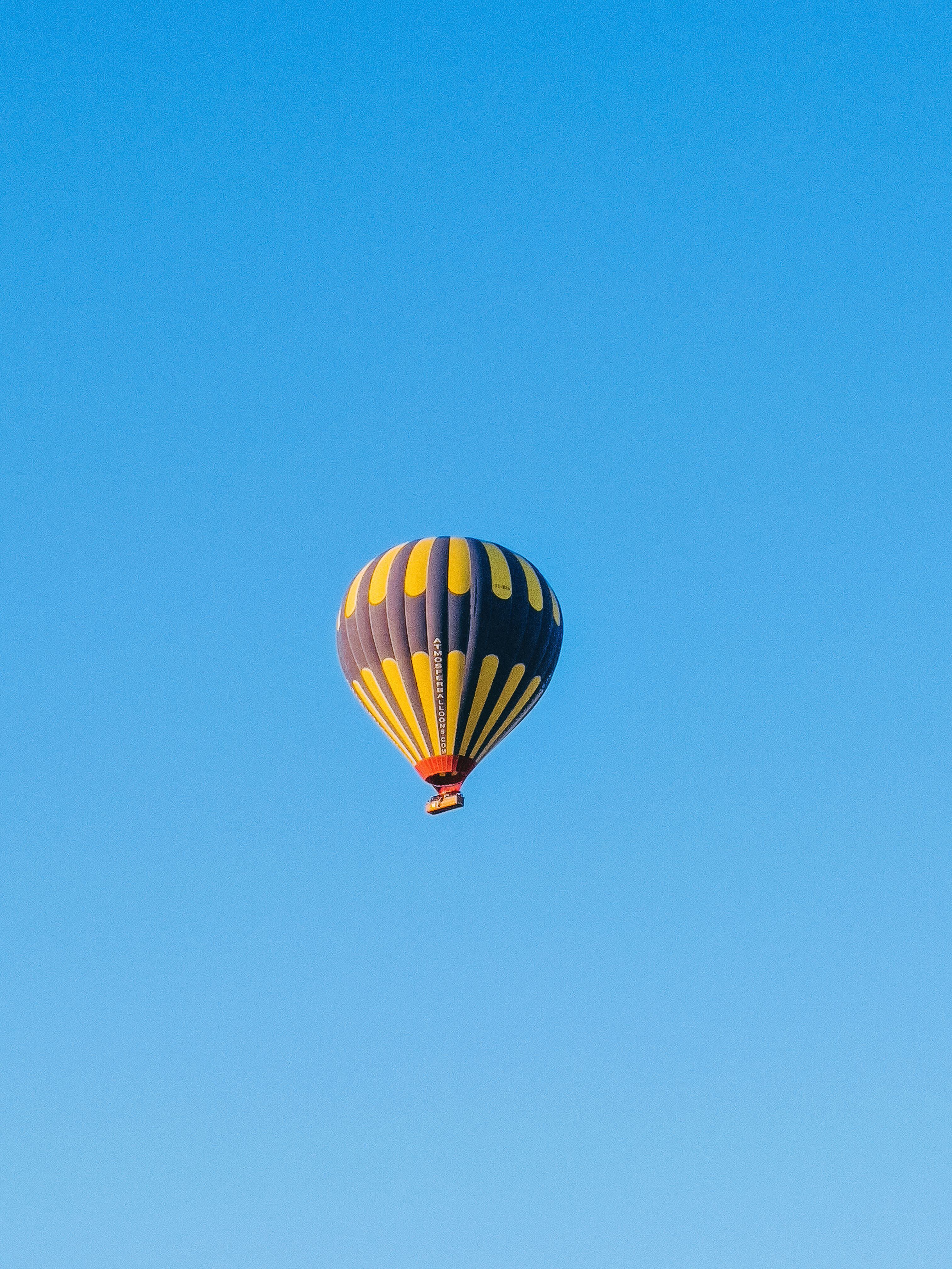 Hot Air Balloon Flying against a Clear Blue Sky · Free Stock Photo