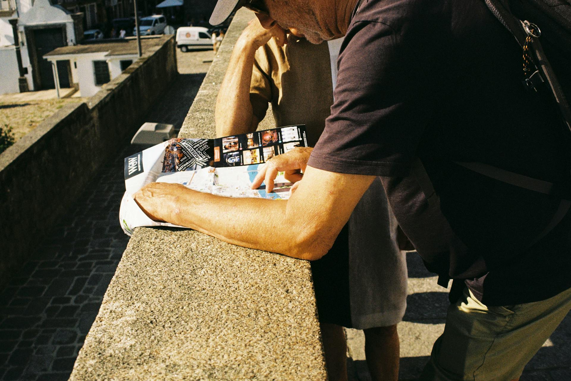 Two tourists exploring Porto by examining a map during the day outdoors.