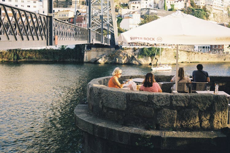 Tourists On The Terrace Of Ponte Pensil Bar By The Luis I Bridge In Porto