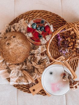 Top view of vibrant fruity cocktails with coconut on a wicker mat, evoking tropical vibes.