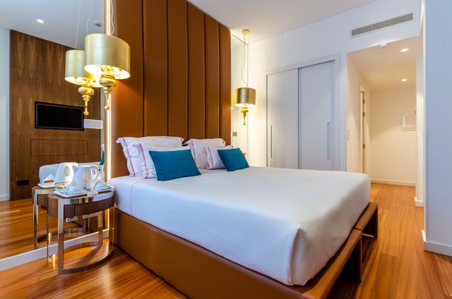 Elegant modern hotel room with plush bedding and warm lighting in Lisbon, Portugal. Related image for Guest Experience: How Brands Can Improve Performance.