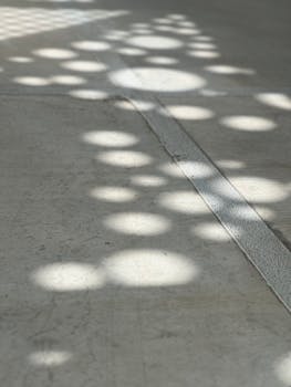 Unique shadow patterns on concrete pavement in Birmingham, England.