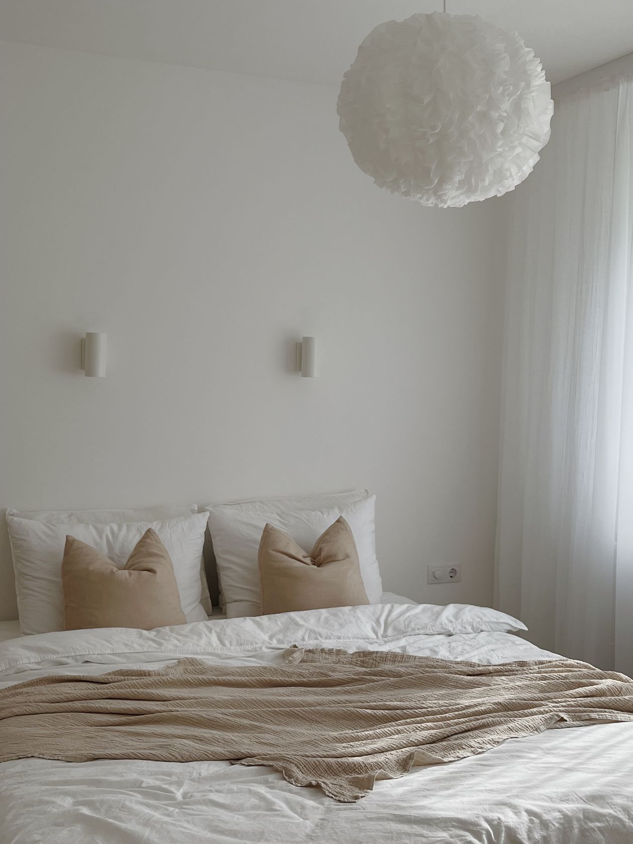 Small bedroom in calm neutral tones with soft bedding.