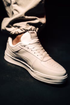 Stylish white Puma sneaker highlighted against a black background, perfect for fashion and footwear themes.