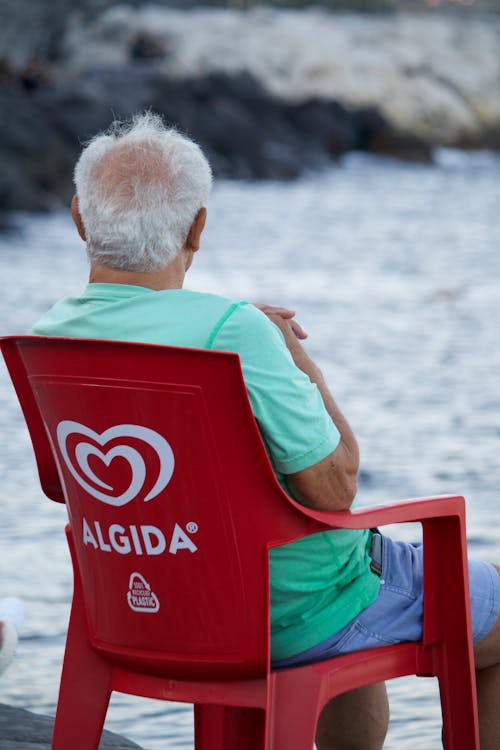 Man Sitting on Algida Red Chair