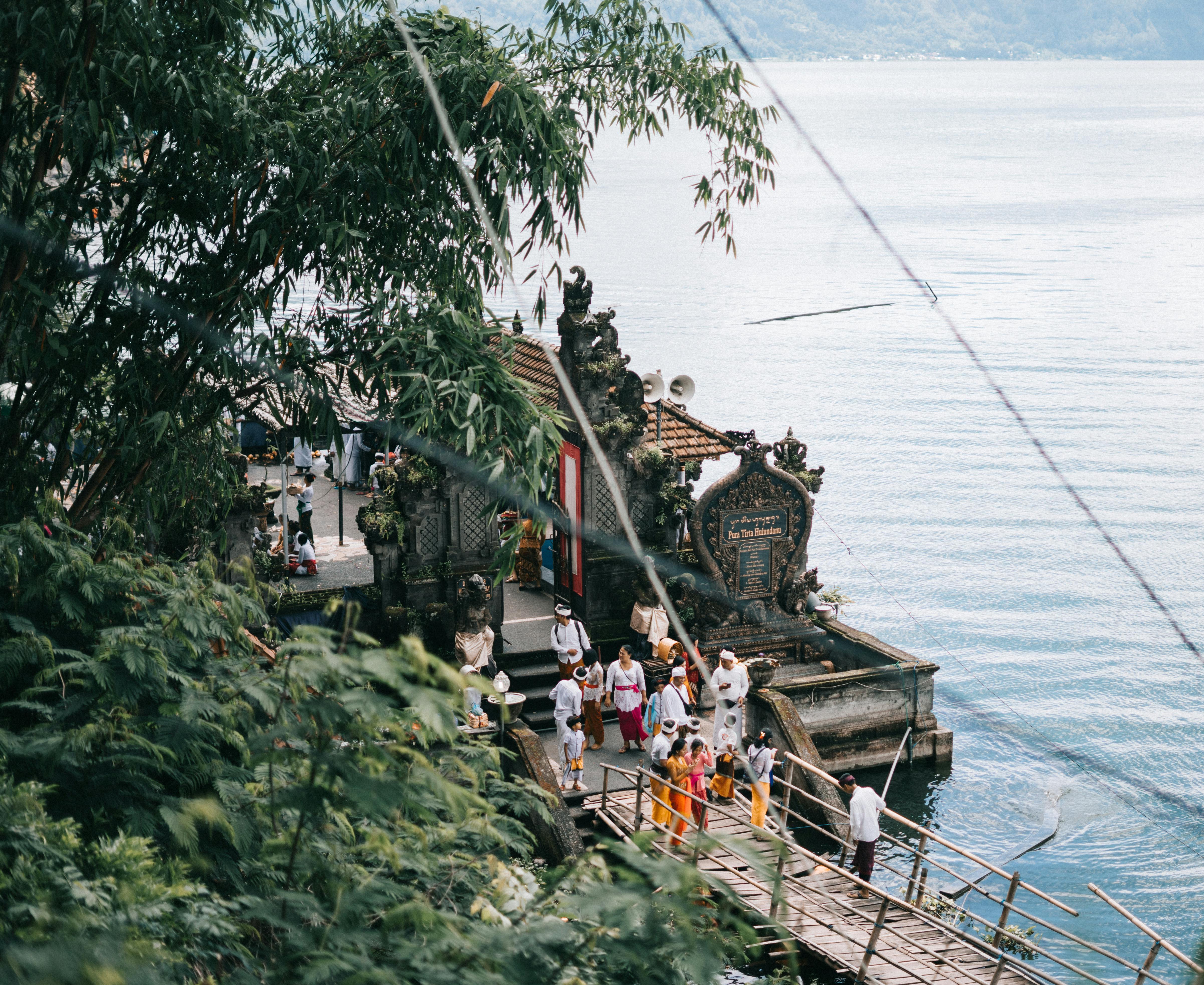 在印度尼西亚巴厘岛，一群人聚集在一个由宁静湖泊环绕的传统圣地