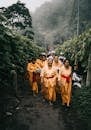 在文化仪式上，一群穿着传统服装的成年人走过森林小路