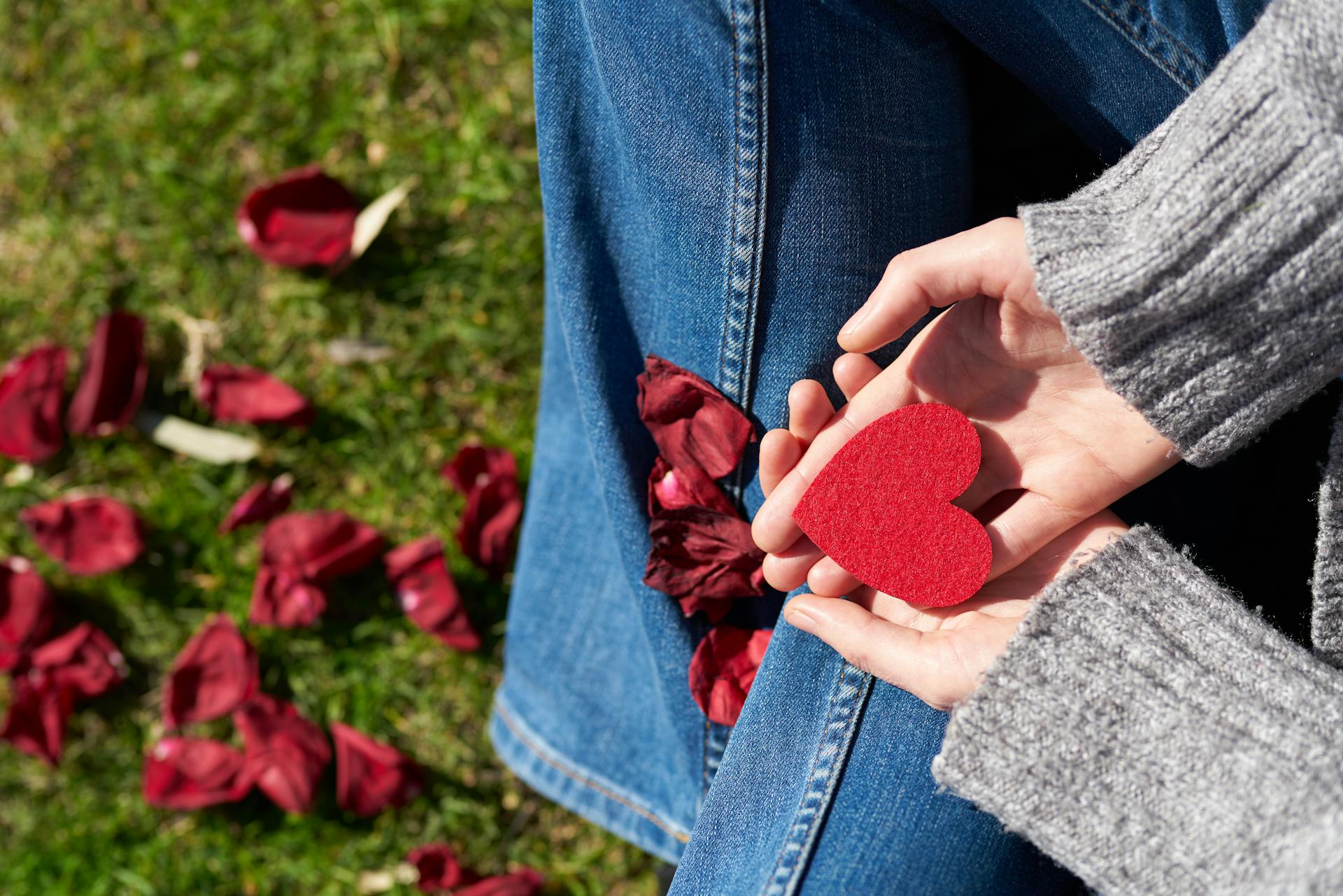 Person Holding Heart Shaped Cut Out