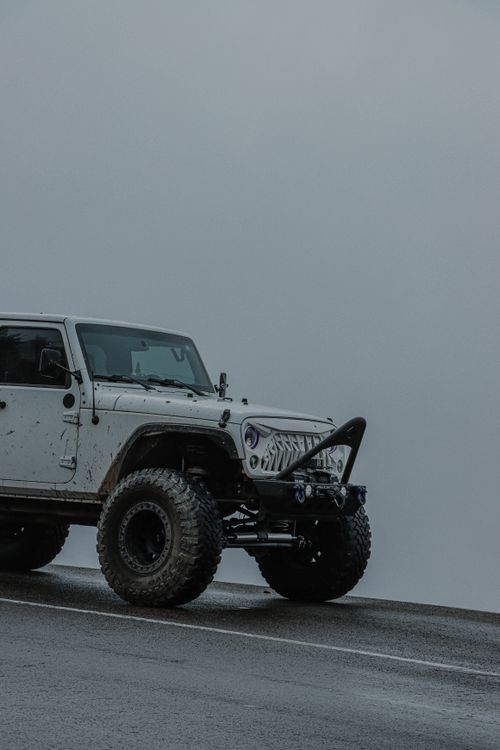 Free White 4x4 Jeep on a foggy road, showcasing off-road adventure potential. Stock Photo