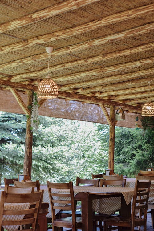 Chairs and Tables of Restaurant on Patio Under Wooden Ceiling
