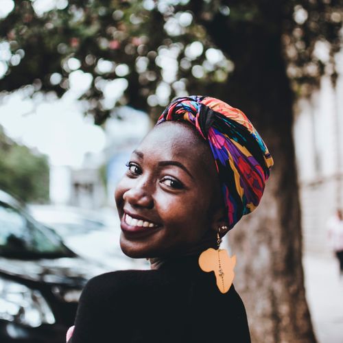 Smiling designer in a patterned headwrap — photo by Mwabonje Ringa on Pexels
