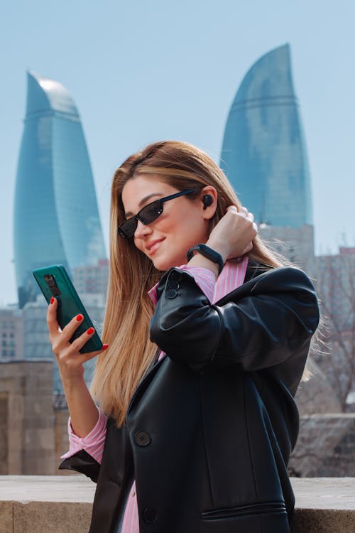 Businesswoman with Smartphone against Flame Towers in Baku