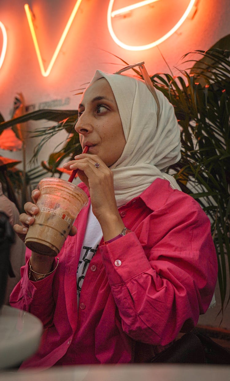 Woman In Hijab And Pink Shirt Drinking Coffee