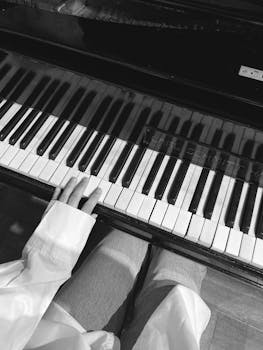 Black and white shot of hands playing a piano, creating music in İstanbul.