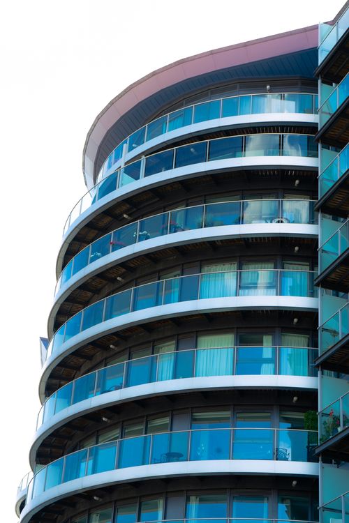 Free Contemporary curved apartment building featuring glass balconies and modern architecture. Stock Photo