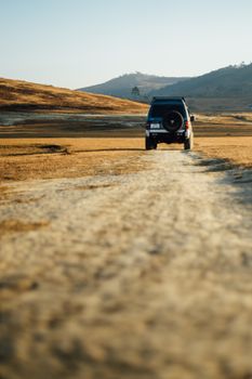 4x4 vehicle on a dirt road in rural landscape, perfect for adventure exploration.