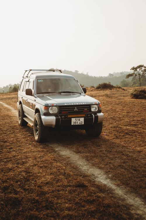 Free A Mitsubishi Pajero navigating a rural dirt road, perfect for adventure enthusiasts. Stock Photo