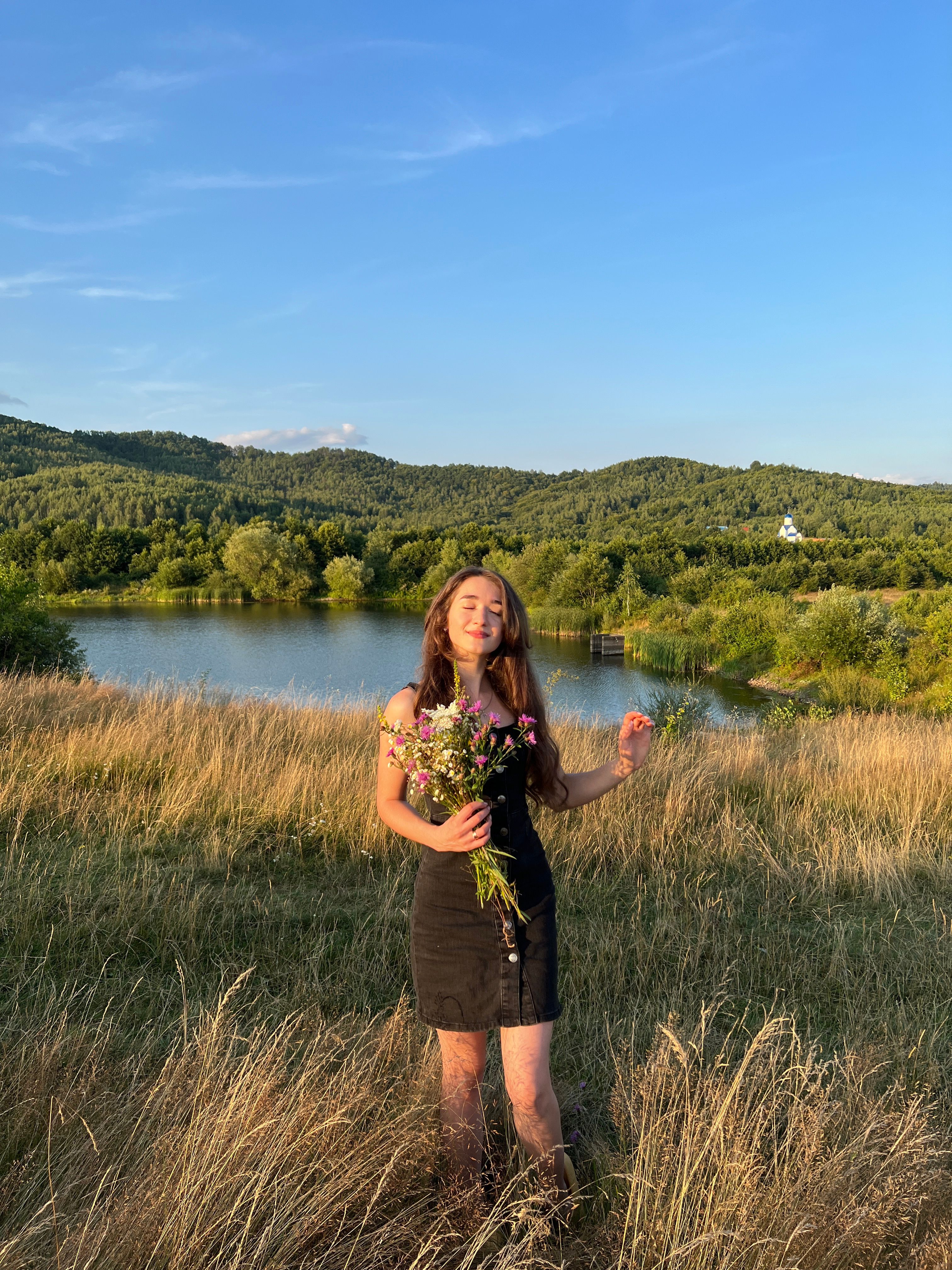 Young Cute Girl Standing on a Field Holding a Bouquet of Flowers · Free ...