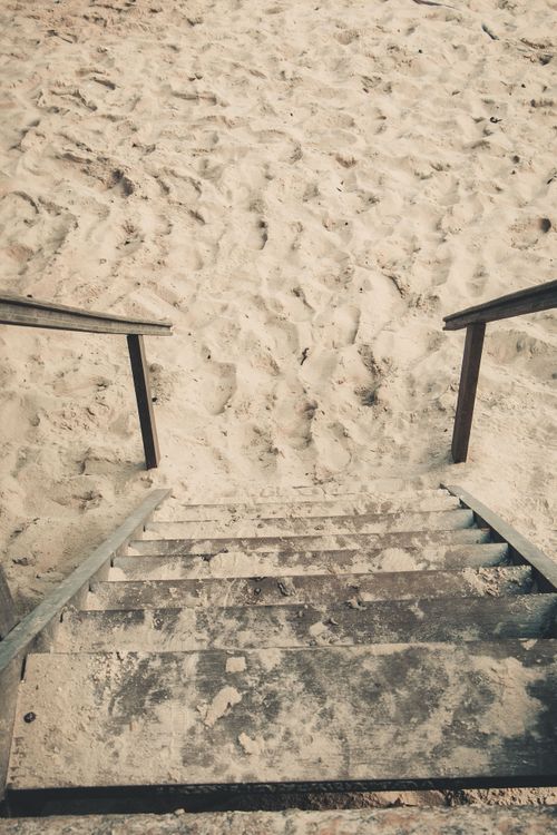 Free Wooden steps leading to a sandy beach in Rio de Janeiro, creating a rustic coastal scene. Stock Photo