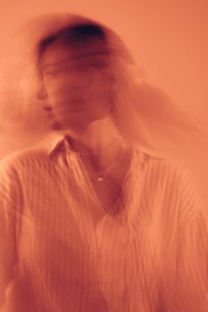Creative motion blur portrait of a woman in warm tones.