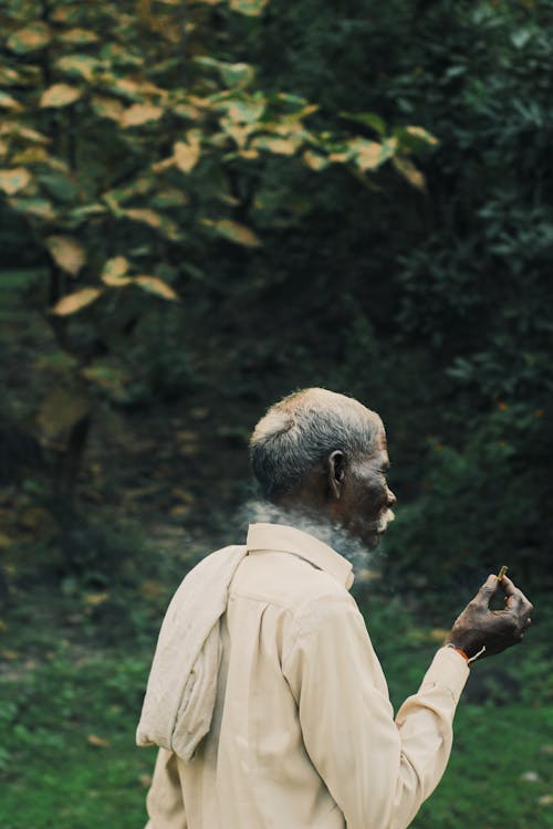 Black Old Man Holding a Cigarette in the Park