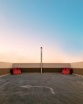 Minimalist rooftop parking scene with sunset sky, capturing urban solitude.