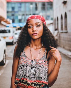 一位时尚女士戴着头巾和太阳镜，自信地在热闹的城市街道上摆出姿势