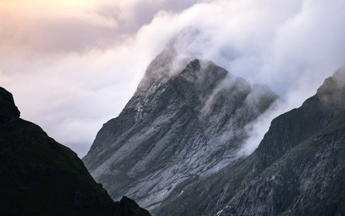 Free Dramatic mist-covered mountain peaks in Norway captured during sunset. Stock Photo
