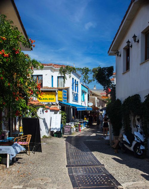Free Charming view of Sığacık street with shops and cafes under blue sky. Stock Photo