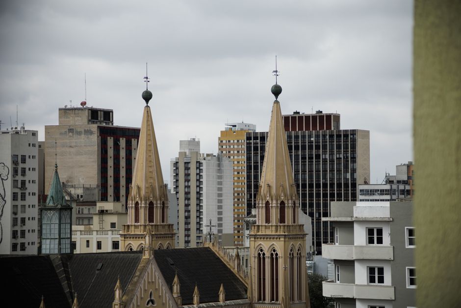Skyline view of Curitiba with historic church spires against modern buildings.