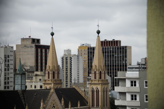 Skyline view of Curitiba with historic church spires against modern buildings.