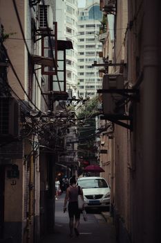 Urban alley in the city, featuring walkers and looming skyscrapers, showcasing urban life dynamics.
