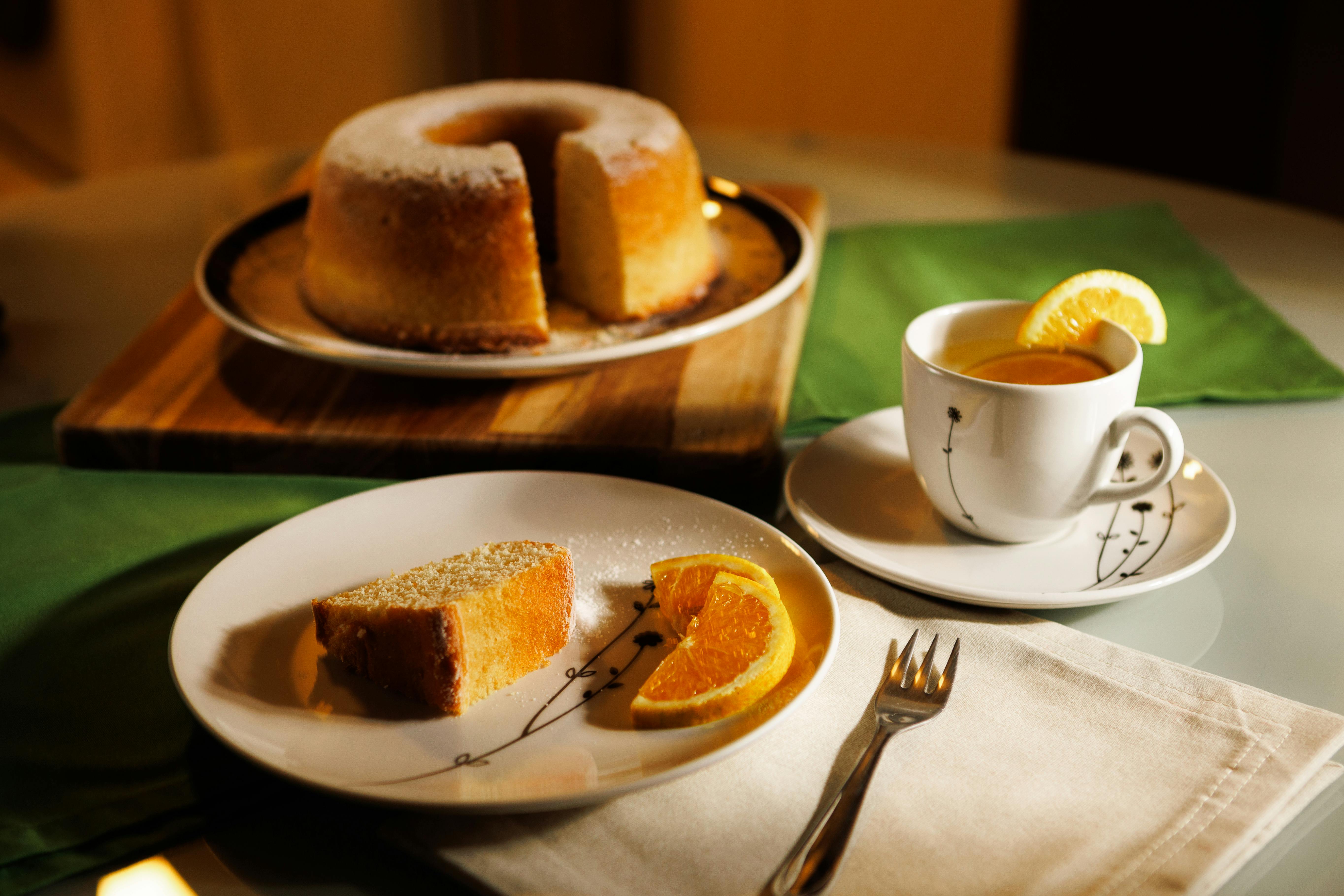 A cozy setting with lemon tea and orange cake on a table, ready to enjoy.