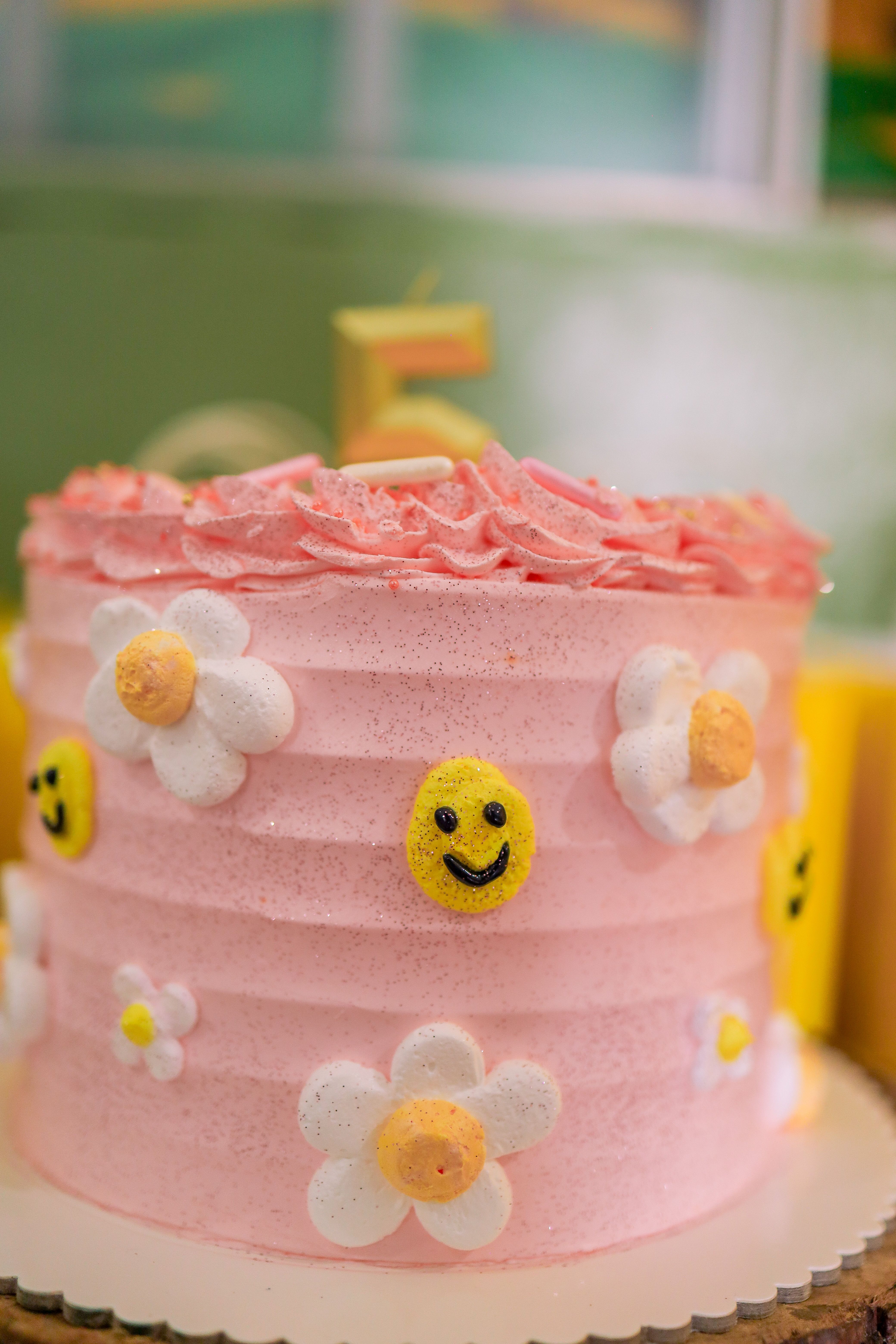 Playful pink cake with flowers and smiley faces