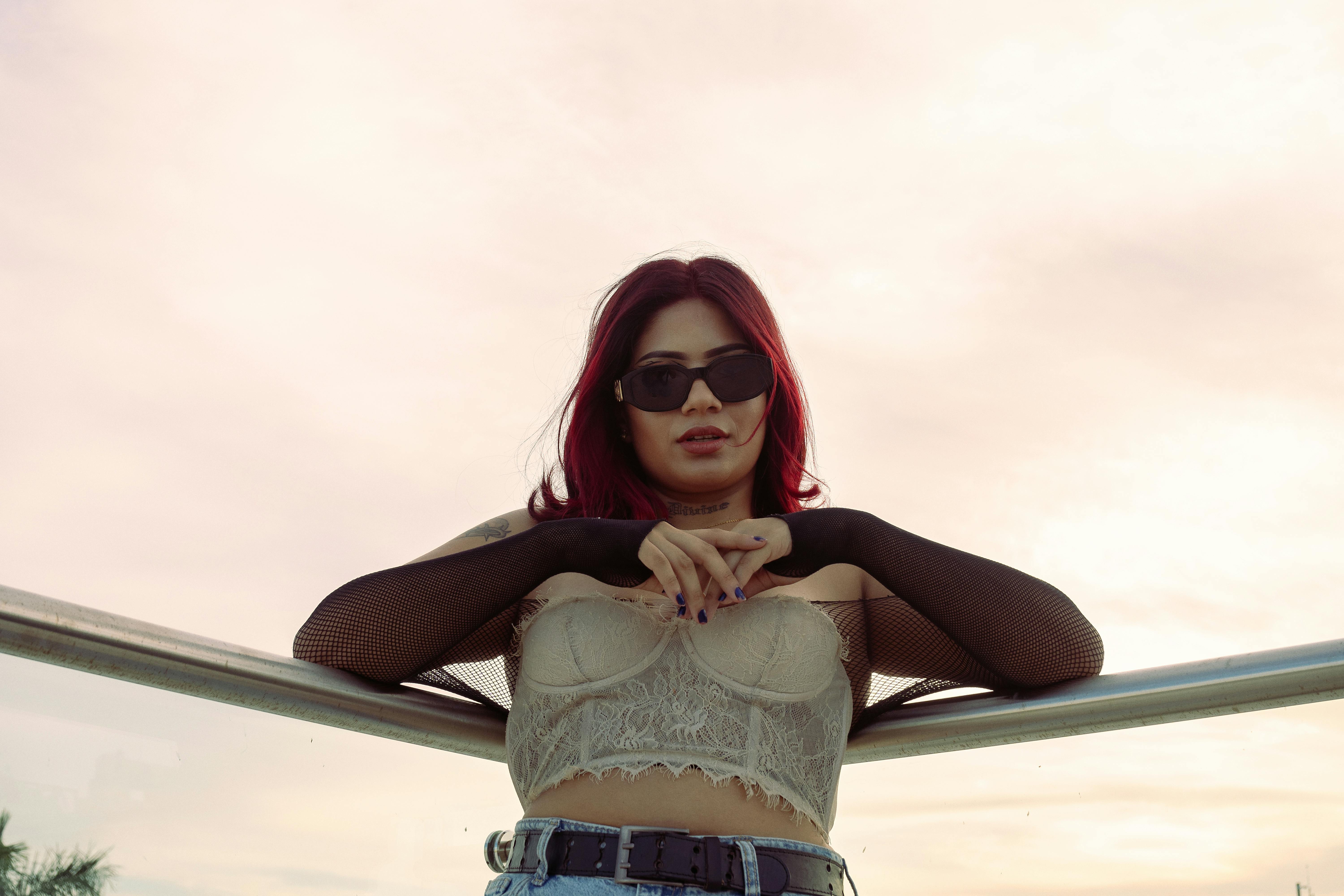 A stylist layering a structured black leather corset belt over a crisp white oversized shirt, demonstrating silhouette transformation.