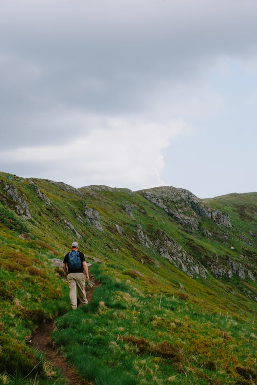 Man Walking on Footpath on Hills