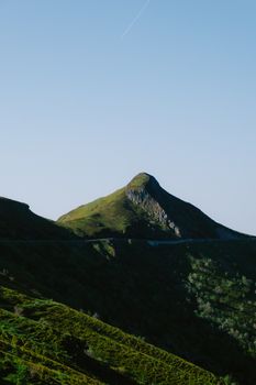 Serene landscape of a green mountain range against a clear blue sky, ideal for nature and travel themes.