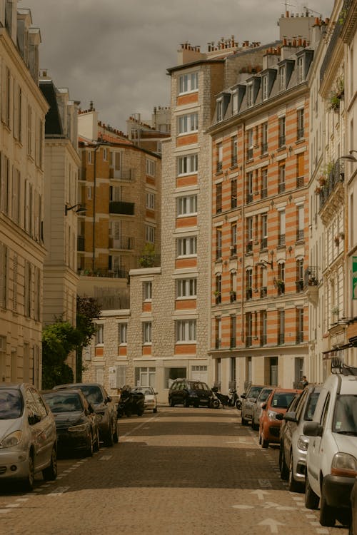 View of a Road between Apartment Buildings in City with Cars Parked on the Sides