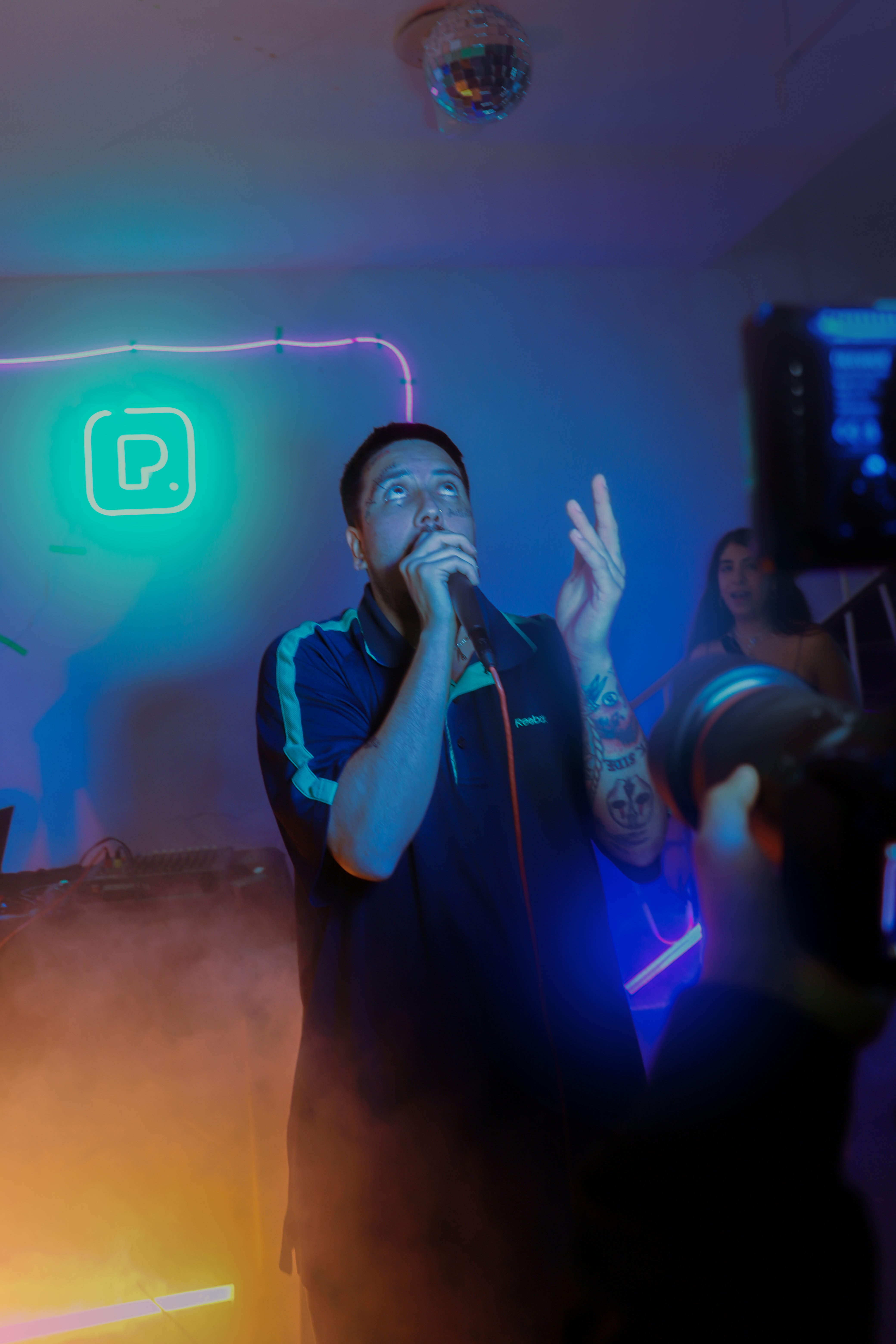 A captivating performance by a male singer with neon lights and a vibrant atmosphere in Mexico City.