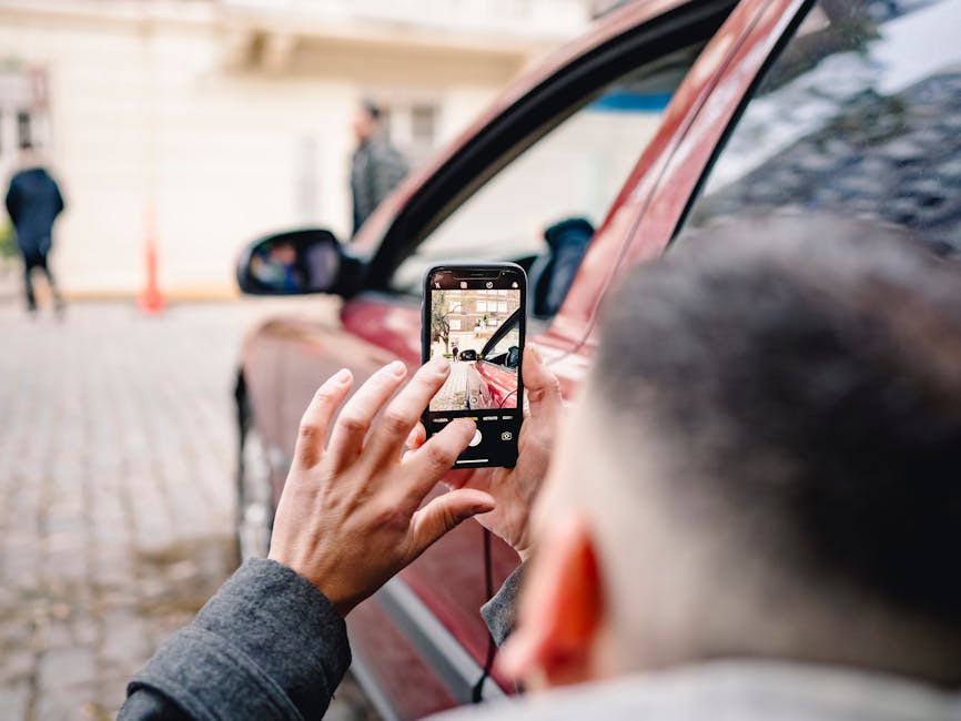 person using their smartphone to photograph car damage at an accident scene - personal injury law firms person using their smartphone to photograph car damage at an accident scene - personal injury law firms