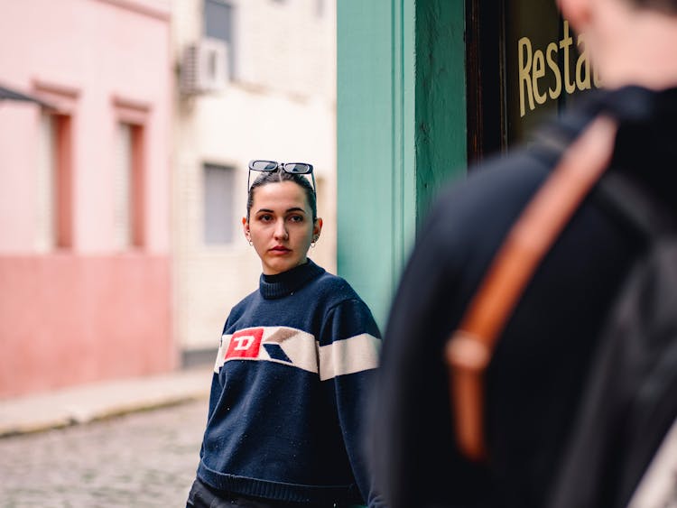 Woman In Blue Sweater Standing At A Restaurant Entrance