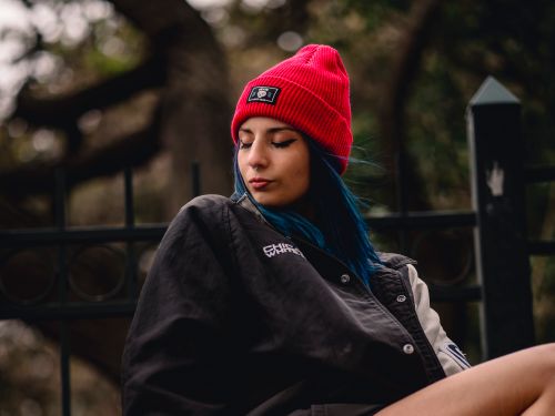 Free Street style photo featuring a woman with blue hair and a red beanie in an urban setting. Stock Photo